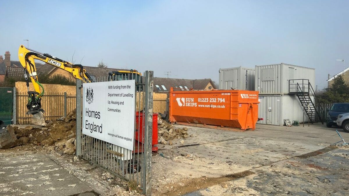 Skip hire lorry collecting waste on a UK road